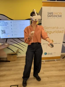 Participante realizando una actividad de realidad virtual frente al banner de la Semana de la Seguridad de L’Oréal.